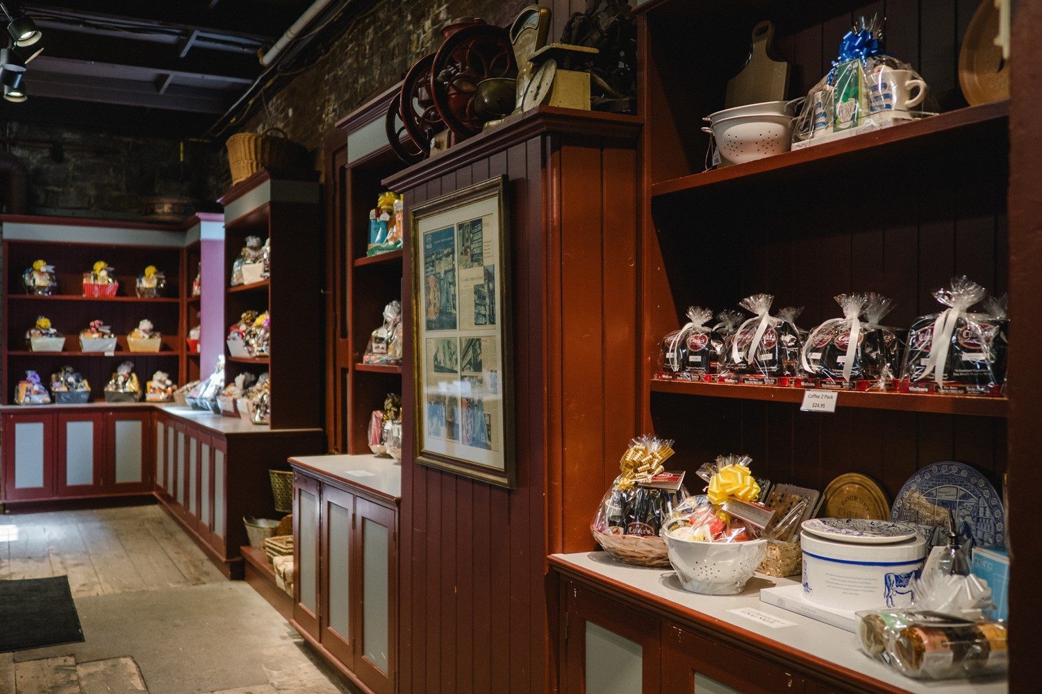 Gift baskets and food arrangements displayed on dark wood shelves at Hartley's
