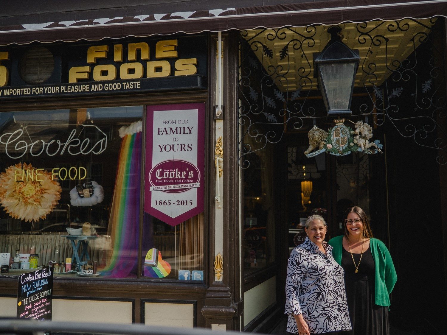 The Hartley's Fine Foods storefront in Kingston, with its gold FINE FOODS sign and family banner in the window